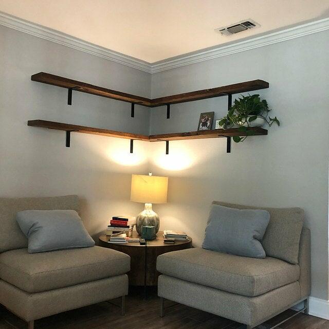 four reclaimed wood wall shelves mitered to fit in an inside corner. Shelves are shown in a cozy corner in the living room in the early american finish.
