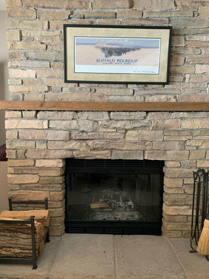 a reclaimed wood floating fireplace mantel in the natural option. Mantel is mounted on a natural stone fireplace with no decor, making it the focal point.