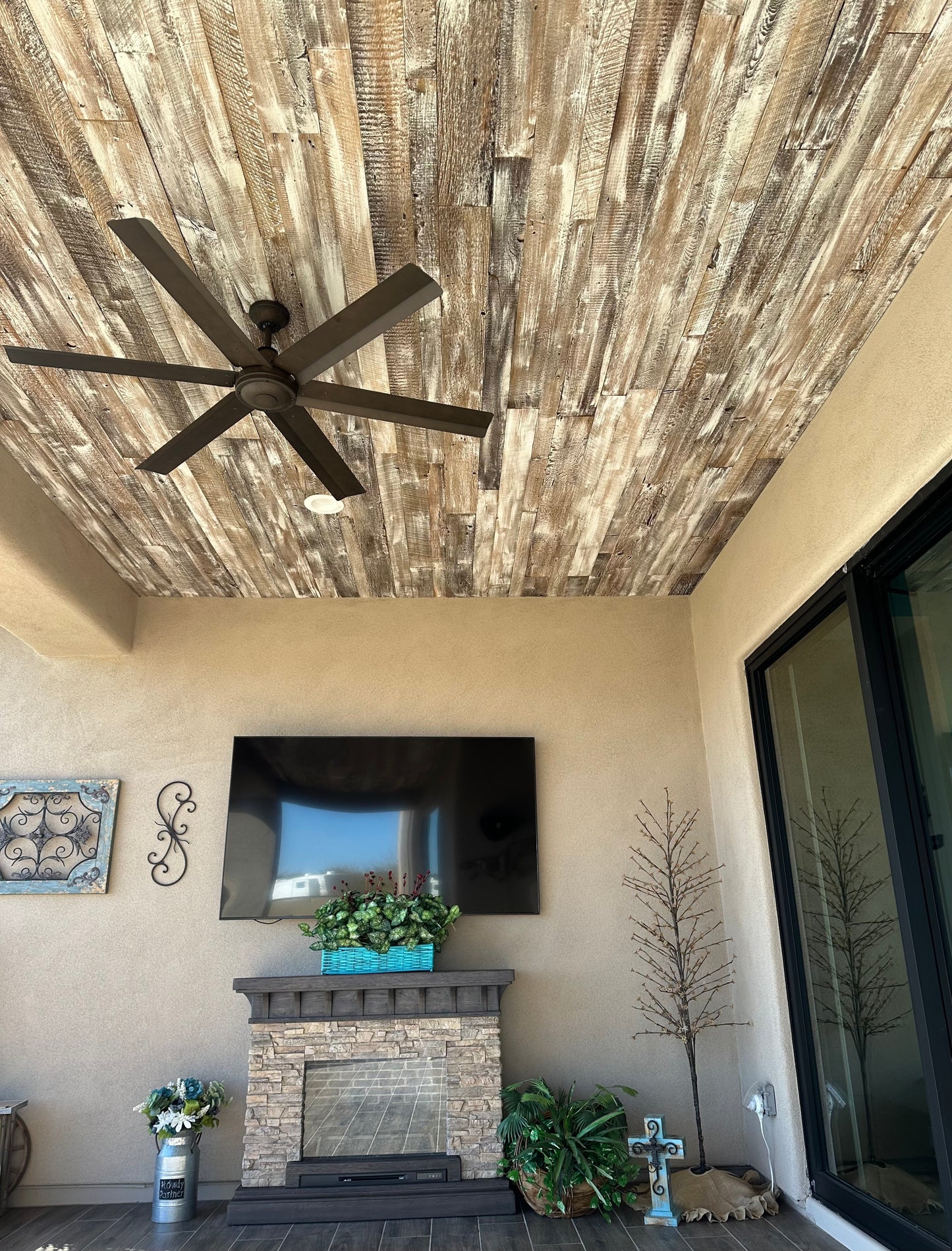 antique white reclaimed barnwood planks used on the ceiling of an outdoor terrace. Wood is brown with a white wash finish applied.