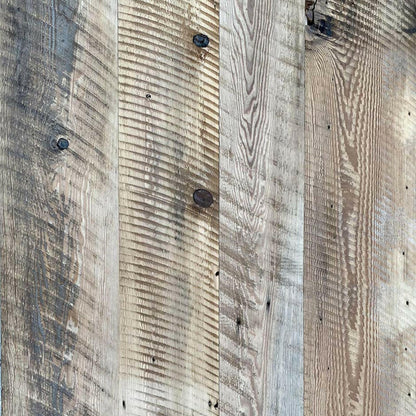 close up of barnwood paneling showing color variations and characteristics such as circular saw markings and knots.