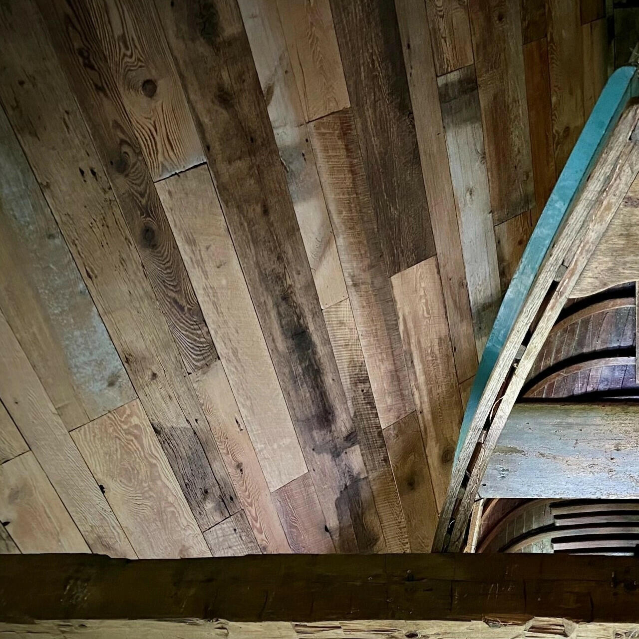 barnwood paneling on a ceiling. Barnwood paneling on wall is varied in width and length, showing many variations and characteristics.