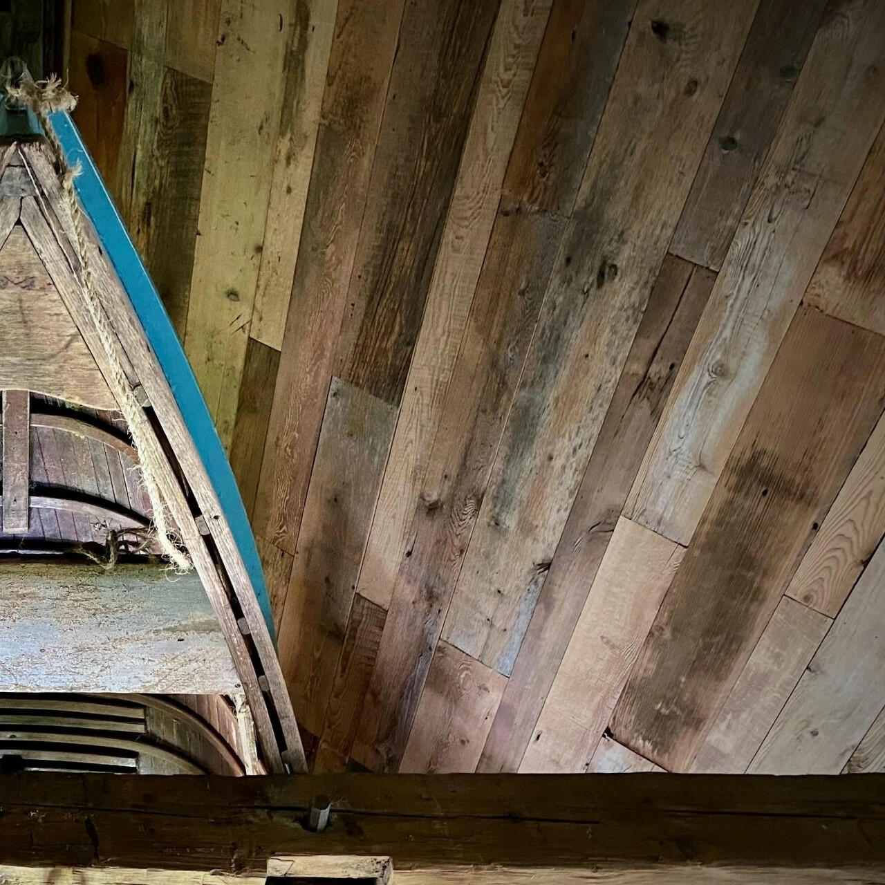 barnwood paneling on a ceiling. Barnwood paneling on wall is varied in width and length, showing many variations and characteristics.