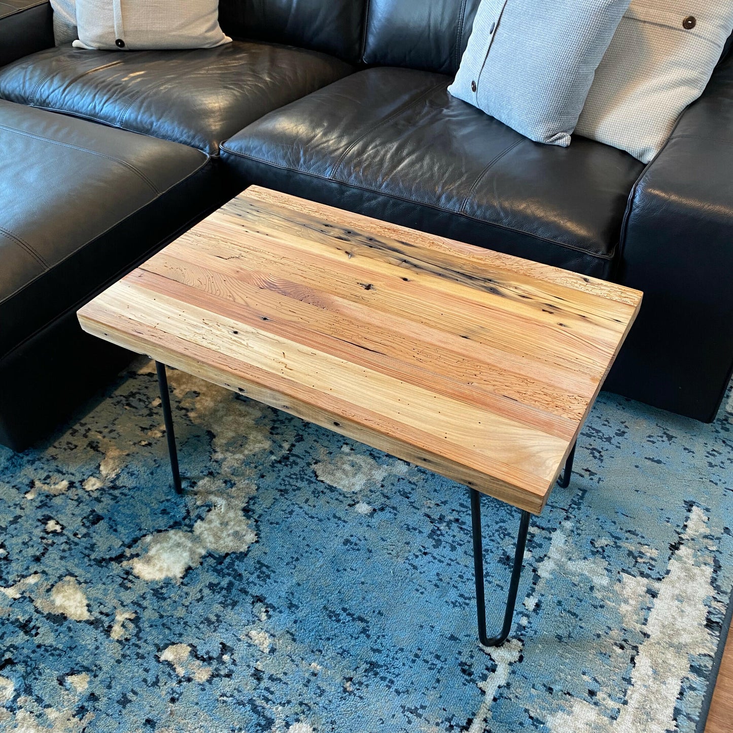 A reclaimed wood coffee table with hair pin legs. The top down view shows variations in the wood and rustic characteristics. The lacquer finish shown adds a slight shine.