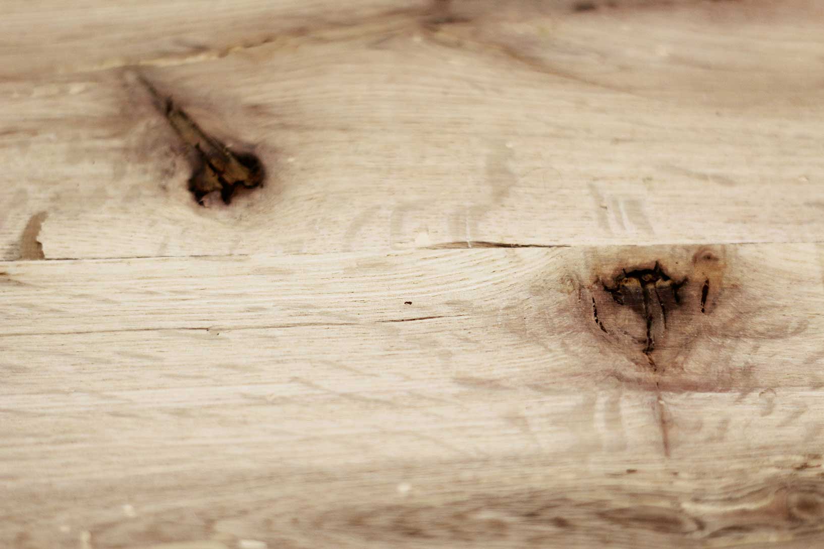 close up of red oak reclaimed flooring. Variations in wood color and grain pattern and knots shown.