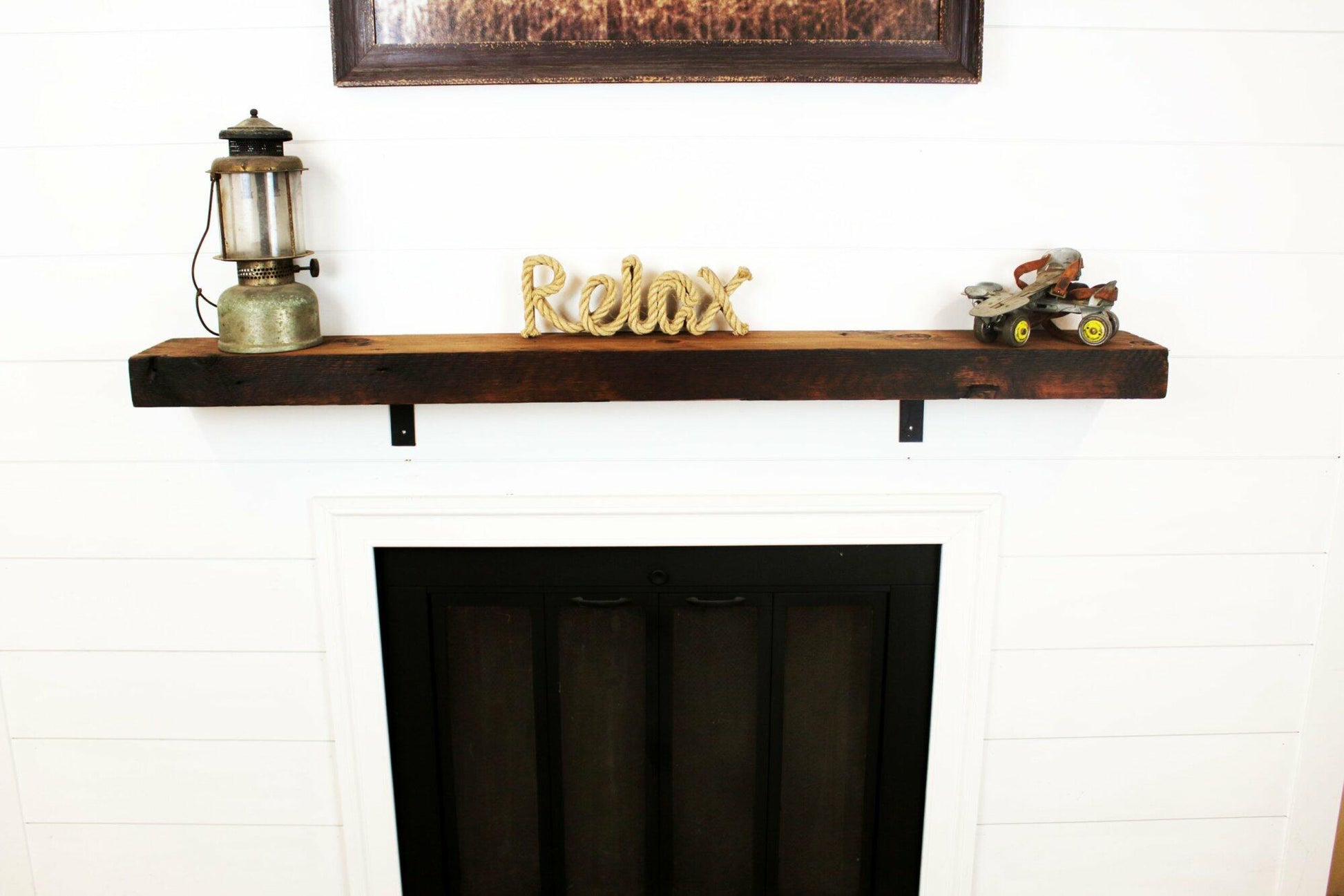 skip-planed reclaimed barnwood fireplace mantel. Front face is darker than top side of mantel.
