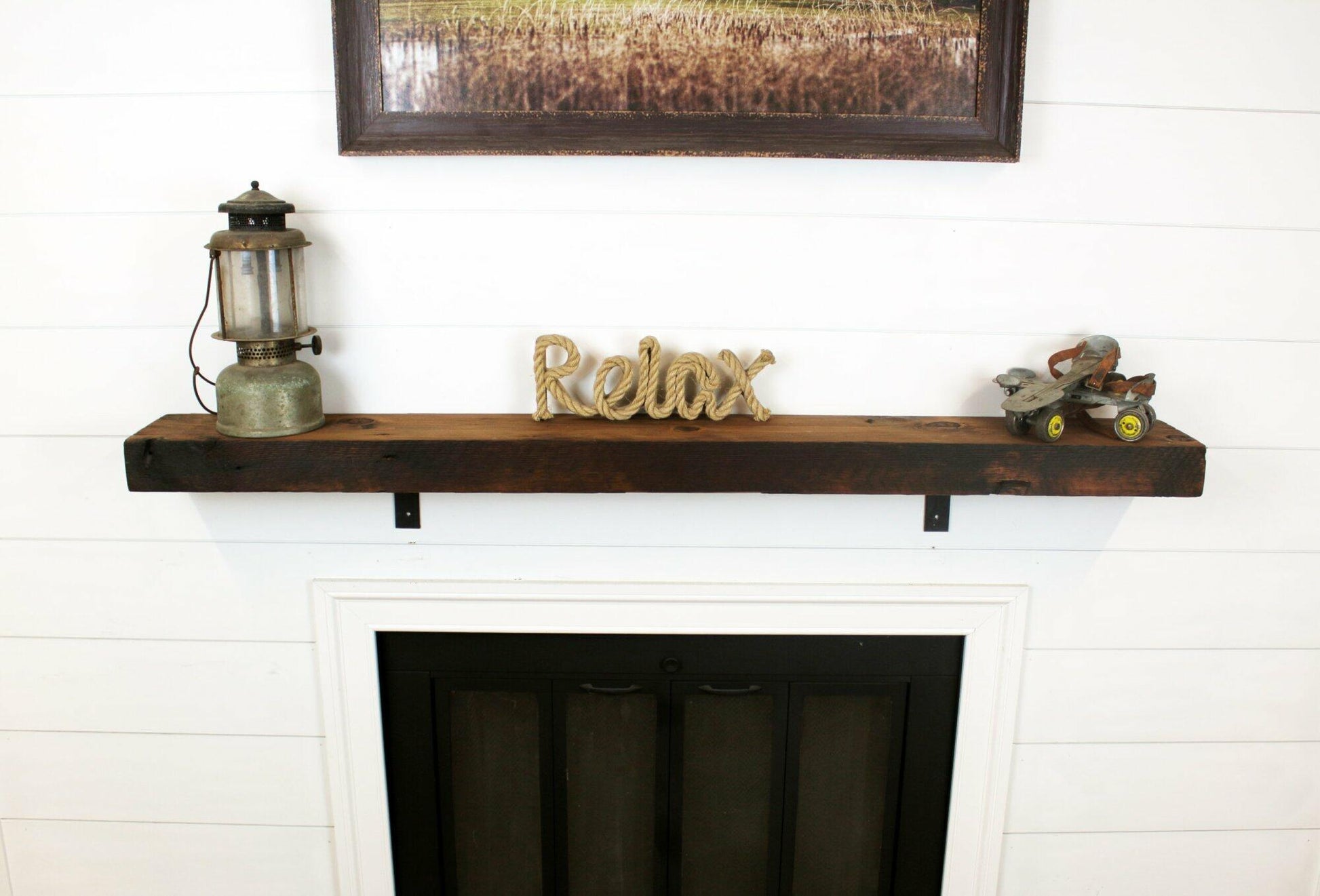 skip-planed reclaimed barnwood fireplace mantel. Front face is darker than top side of mantel.