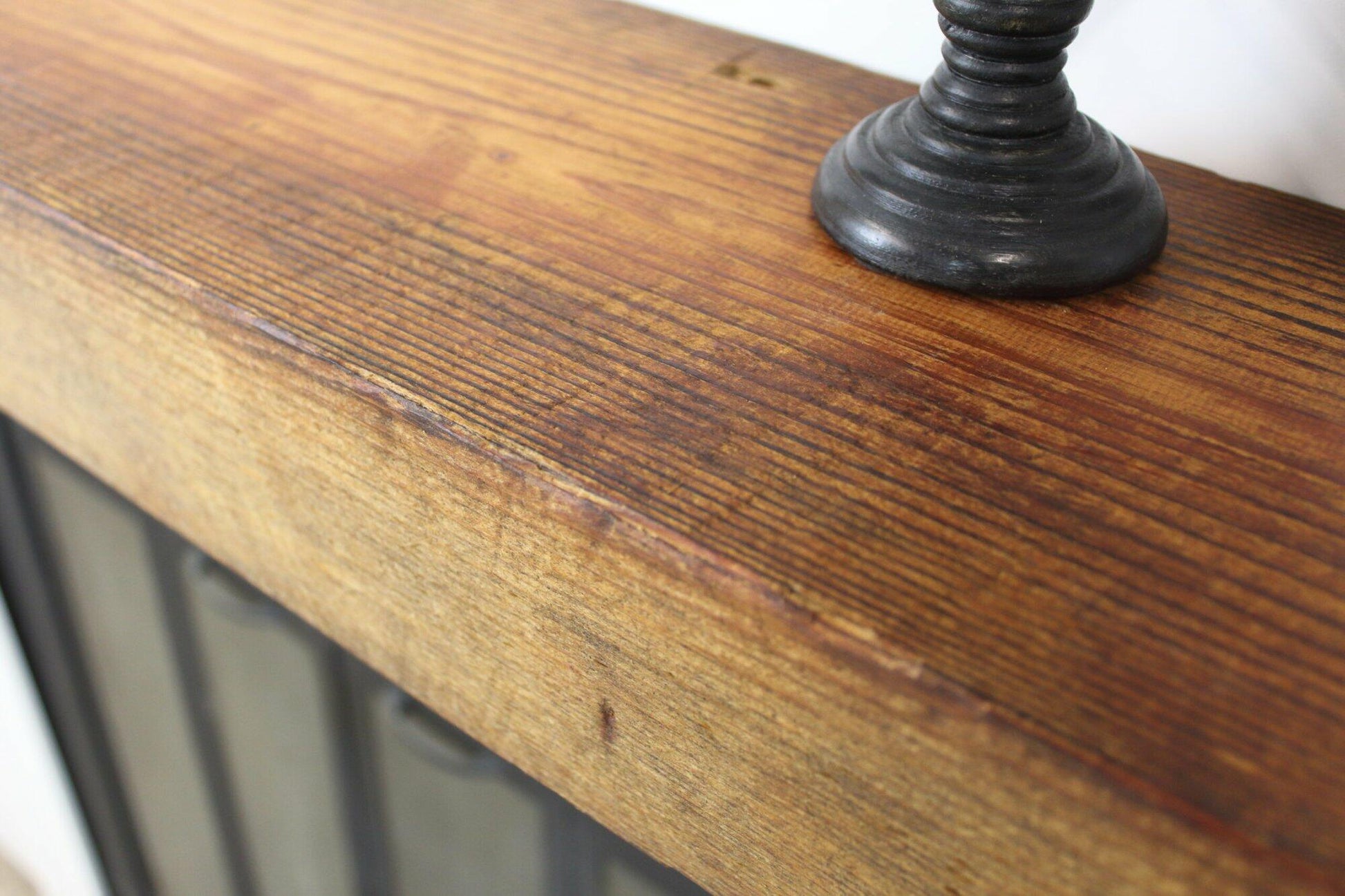 a close up of the top side of a skip-planed reclaimed barnwood fireplace mantel. Close up images shows grain pattern and other variations in the wood.