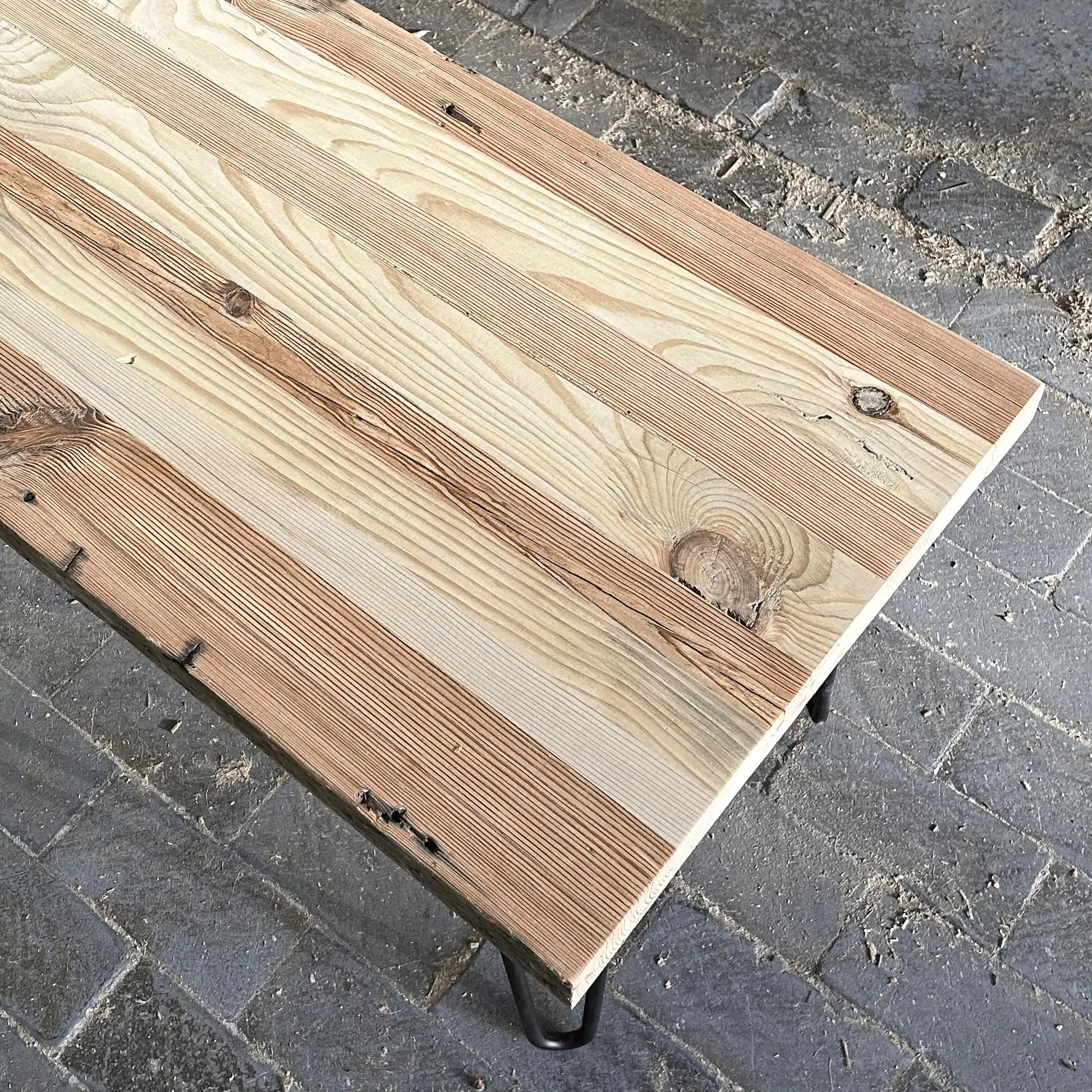 A reclaimed wood coffee table top shows variations in the wood and rustic characteristics. Table finish is unfinished or unfinished sealed.
