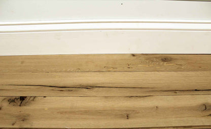 reclaimed white oak flooring installed with baseboard molding. Variations in wood color shown along with knots, checking, and characteristics from previous bug activity.